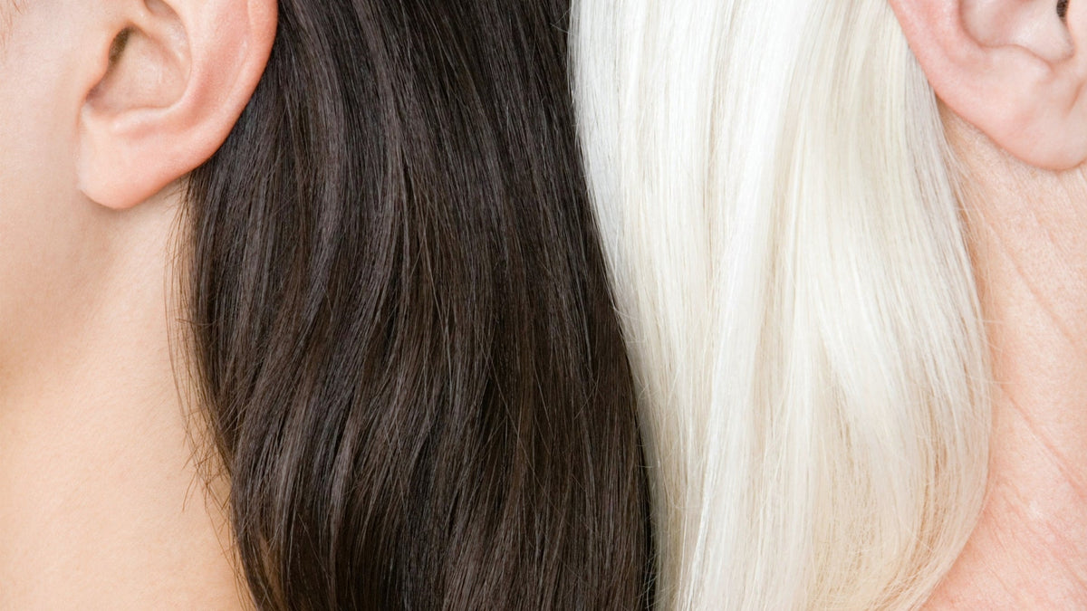 Close-up of dark and white hair side by side, illustrating age-related changes in hair